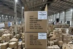 仓库内堆放的运输纸箱，外侧贴有物流条码标签并印有箱唛信息。